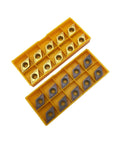 Front view: 20 DCMT turning inserts with gold/gray coating in yellow dual-tray storage boxes.