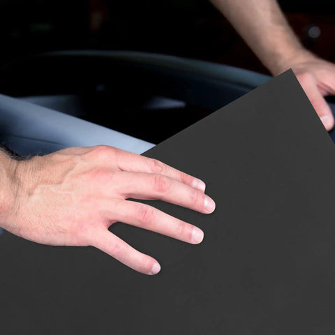 Hand holding a piece of grey super fine carborundum sandpaper from the 10-Pack Super Fine Carborundum Sandpaper Set.