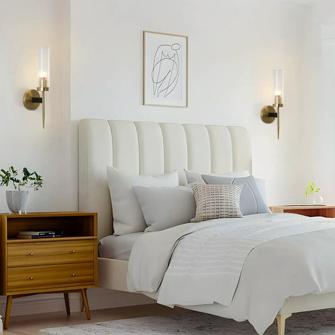 Mid Century Modern Gold Wall Light With Cylinder Glass Shade Brushed Brass Finish Long Wall Sconce For Vintage Bathroom And Hallway Mount Lamp With Lit Glow And Classic Vibe next to a bed in a cozy bedroom.