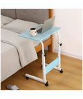 Adjustable Height Rolling Laptop Cart With Spacious Work Surface And Locking Caster Wheels Perfect For Bed Sofa Recliner Or Wheelchair Ready To Roll No Hassle Setup Rock Solid Stand beside a bed with a laptop and coffee.