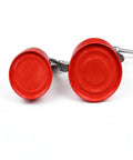 Two red metal hand oil cans with straight spouts and pump levers, placed side by side.