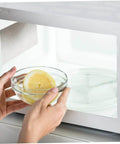 Placing a bowl with a lemon inside a microwave, showing mica sheet waveguide cover in 10 Piece Microwave Waveguide Cover Set With 5.9 By 4.7 Inches