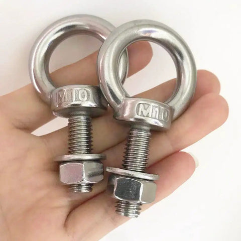 Hand holding two M10 shoulder eye bolts, 304 stainless steel with washers and nuts, close-up view. Heavy duty for indoor outdoor use.
