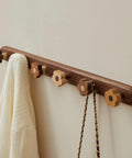 Dang Cute Flower Peg Wall Mount Coat Rack For Kids Crafted From Solid Walnut Wood Storage hanging a white sweater on flower hooks.