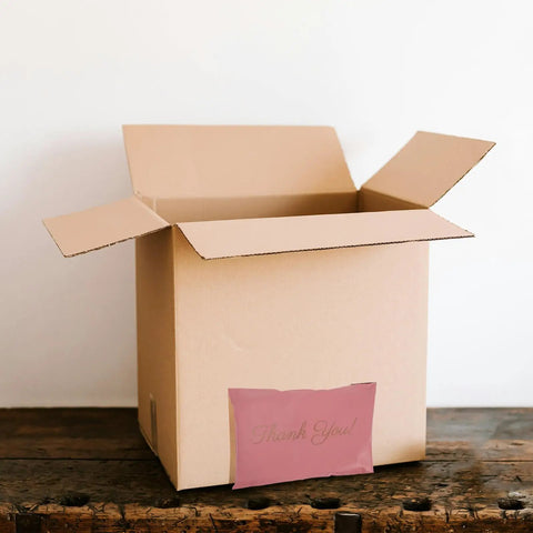 Open cardboard box with Pink 15x27cm Self Sealing Poly Mailer Bags Pack Of 100 Tear-Resistant Shipping Mailers for Small Business outside