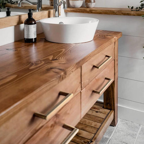 Wooden vanity with 5 Inch Antique Brass Cabinet Pull Handles, 6 Pack, Grooved Texture Non Slip Grip, installed in rustic bathroom.