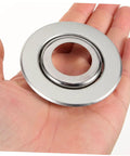 Hand holding a stainless steel fire sprinkler escutcheon plate, 6.7 cm square for home or office sprinkler head upgrade.
