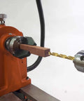 Pen drilling lathe chuck, 2-inch, 2-jaw, mounted on orange wood lathe with a wooden blank; 1" x 8TPI direct thread.