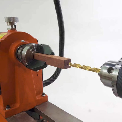 Pen drilling lathe chuck, 2-inch, 2-jaw, mounted on orange wood lathe with a wooden blank; 1" x 8TPI direct thread.