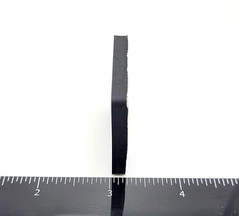 Side view of a 1.5-inch square silicone rubber stick-on foot bumper showing the thickness with a ruler for scale. Non-slip adhesive pad.