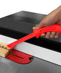 Red ergonomic grip from 4 Piece Pro Grade Safety Woodworking Push Sticks Set for Table Saw and Jointer with blade visible