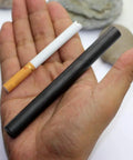Hand holding XL Survival Ferro Rod Half Inch By Five Inch Fire Starter With Drilled Flint Steel next to a cigarette for size comparison