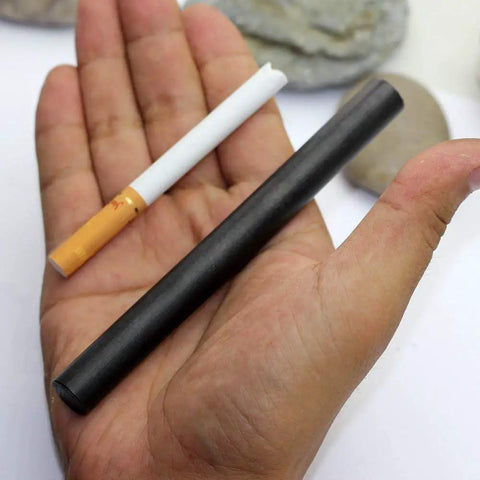 Hand holding XL Survival Ferro Rod Half Inch By Five Inch Fire Starter With Drilled Flint Steel next to a cigarette for size comparison