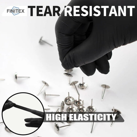 A hand wearing Heavy Duty 3.5 Mil Nitrile Disposable Gloves In Bold Black picks up a metal fastener, showcasing tear resistance.