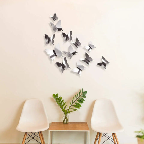 3D Mirror Butterfly Wall Decor Kit With 48 Removable Stickers In Silver Finish displayed on a living room wall with chairs and table.