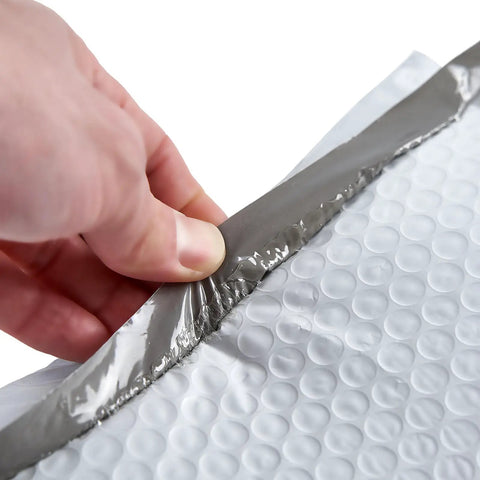 Hand peeling adhesive strip on White Bubble Padded Poly Mailer Bags 9.5 X 13.5 Inches Self Seal Opaque Envelopes Tear Proof