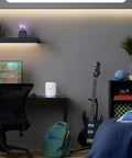 Eero Pro 7 Tri Band Mesh WiFi 7 Router on desk with guitar and chair, offering gig speed up to 5 Gbps in a small office setup