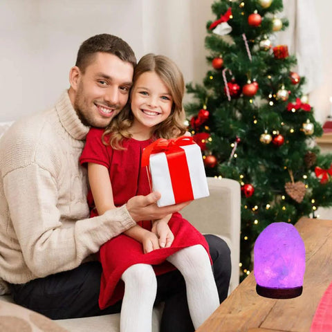 Father and daughter beside Christmas tree with Himalayan Salt Lamp With 8 Color Changing Glow For A Cozy Lit Vibe 100 Percent Natural Crystal Salt Light Handcrafted Night Light For Ambient Decor And Gift Idea For Wellness And Calm Living.
