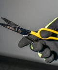 Black-gloved hand holding yellow-handled snip from Cable Splicer Kit With Electricians Knife And Free Fall Snip Includes Leather Tool Holder For Belts Up To Two Inches The Essential Gear For Cable And Phone Techs On The Job.