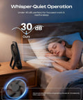 Portable 6.5 Inch Desk Fan With 4000mAh Battery And USB Power Cordless Personal Fan Four Speeds Quiet For Office Travel Home And Sleep LED Display Foldable Black placed on bedside table, woman sleeping.
