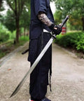 Person holding Hand Forged Longquan Style Dao Sword With High Carbon Steel Blade Full Tang And Dope Matte Black Wooden Scabbard