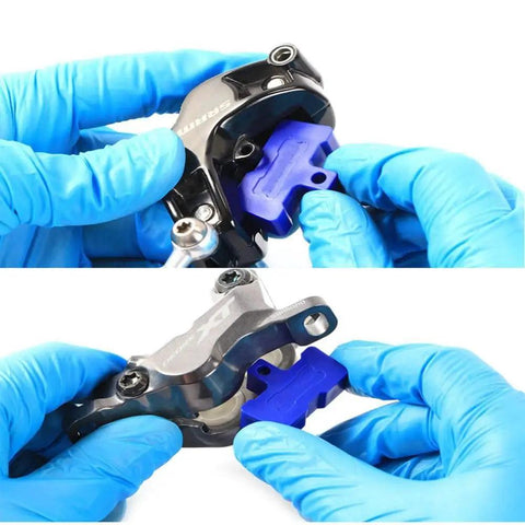 Hands inserting Must Have 9 Pack Bike Brake Pad Spacers Set Universal Hydraulic Disc Brake Bleed Block into caliper for Shimano 2 4 Piston.
