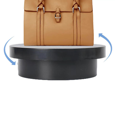 Cool Electric Turntable Display That Spins Your Goods 360 For Amazing Trade Fairs And Photo Shoots Plus It Runs On USB To Keep Things Easy And Green with a handbag on a rotating black base.