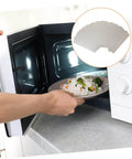 Person placing food in a microwave, illustrating the use of Six Pack Microwave Mica Sheet Heat Insulation Covers For Everyday Use