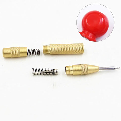 Slick Badass Automatic Center Punch For Metal And Woodworking disassembled with gold finish brass and spring mechanism for drill alignment.