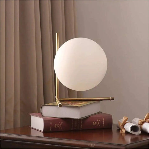 Mid Century Modern Brass Table Lamp With Gold Glass Globe Contemporary Desk Light on books in cozy home setting