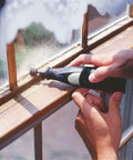Person using Knockout 384 Piece Sanding Drum Kit Featuring 360 Abrasive Sleeves And 24 Steel Mandrels on window frame.