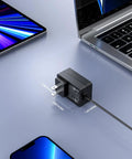 Built Tough As Nails Yet Rock Solid 12V 2A Laptop Power Adapter Wall Charger on a desk beside a smartphone and laptop.