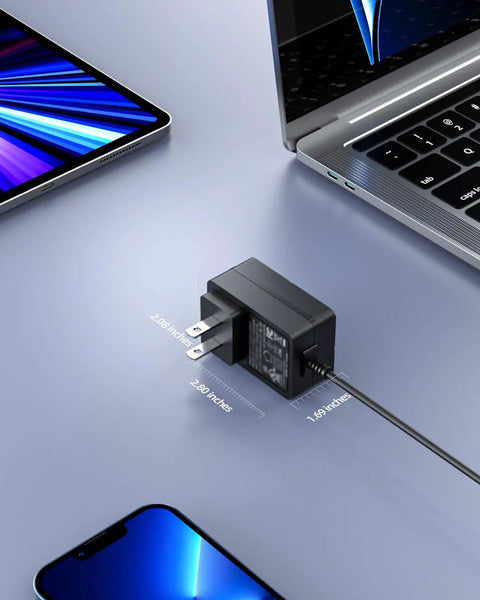 Built Tough As Nails Yet Rock Solid 12V 2A Laptop Power Adapter Wall Charger on a desk beside a smartphone and laptop.