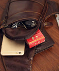 Genuine Leather Sling Backpack For Men And Women Crossbody Day Pack open with phone and essentials visible, in brown cowhide leather.