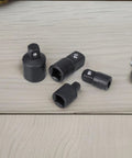 Premium Black Socket Adapter Set With Four High Carbon Steel Pieces In One Quarter Three-Eighths And Half Inch Sizes For Ultimate Toughness And Easy Tool Access To Handle Heavy Impact Jobs. black impact socket adapters on wood surface