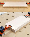 Positionable T-Track Hold Down Clamp Kit For CNC Routers And T-Slot Clamps used to secure wood on a perforated table