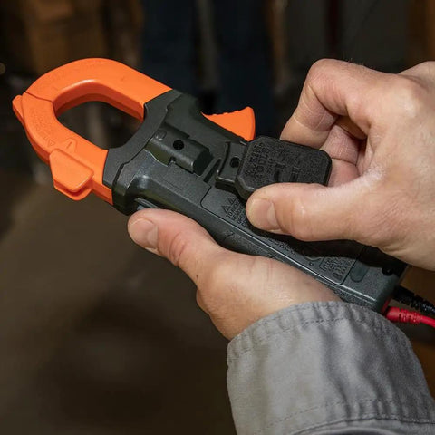 Hands holding clamp meter equipped with Magnetic Hanger For Clamp Meters And Multimeters With Powerful Rare Earth Magnets