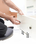 Person using 141 Piece Black Aluminum Alloy Bed Hardware Replacement Kit for DIYers and Pros for drawer assembly