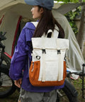 Rear view of a person wearing a Go To Lightweight Waterproof Backpack For Everyday Adventure, Large Capacity Daypack For Hiking Travel And Outdoor Camp Gear, Built Tough For Men And Women in a campsite setting.
