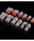 Pro Grade Hella Weatherproof Auto Connectors With 18 AWG 15Cm Wires For Rock Solid Wiring Harness Repairs 12 Pin Male Female Spade Terminals Smooth Seal 100 Set Bulk Pack gray automotive connectors displayed on black background.
