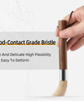 Hand holding Air Blower And Cleaning Brush Kit For Espresso Machines And Coffee Grinders, Walnut handle, bristles visible