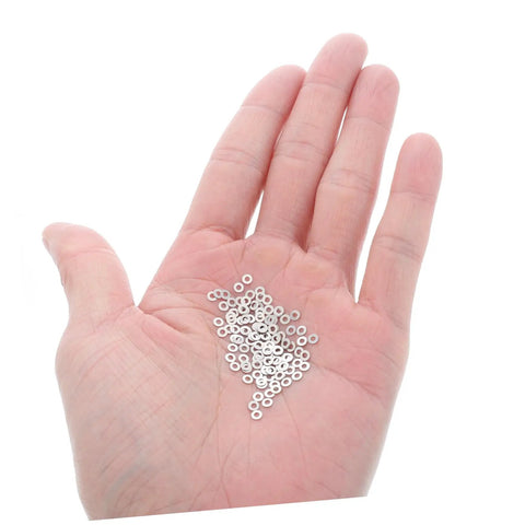 Hand holding 200Pcs Eyeglass Flat Washers Gaskets For Rimless Frames Metal Fasteners For Quick Repairs And Maintenance Pro Grade Go To Replacement Compatible With Spectacle Frame Repair And Rimless Glasses Round Flat Washers For Comfort And Support.