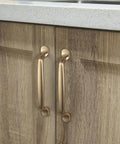 Installed Six Pack 5 Inch Center To Center Arch Cabinet Pulls in champagne bronze finish on wooden kitchen cupboards