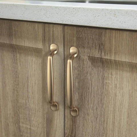 Installed Six Pack 5 Inch Center To Center Arch Cabinet Pulls in champagne bronze finish on wooden kitchen cupboards