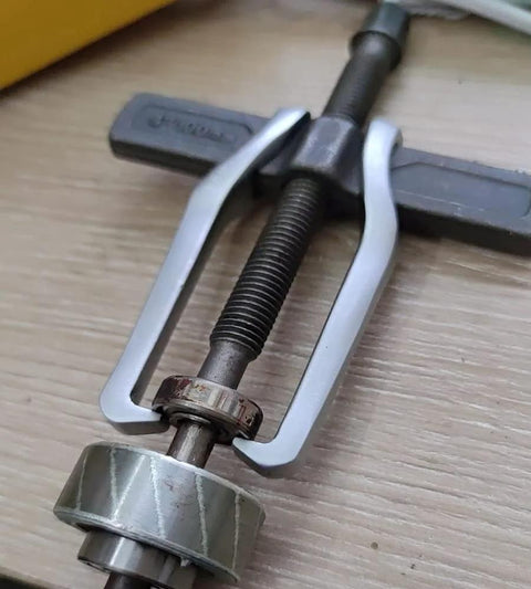 Heavy Duty 2 Jaw Puller With Single Hook Lifting Tool in use, chrome vanadium steel, extracting bearing from hub.