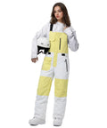 Model wearing Waterproof Insulated Ski Bibs For Men And Women, windproof adjustable yellow and white snow overalls, holding helmet.
