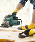Person using a saw on a wooden board with protective gloves, related to Double Sided Woodworking Tape For CNC Templates And Pattern Routing.