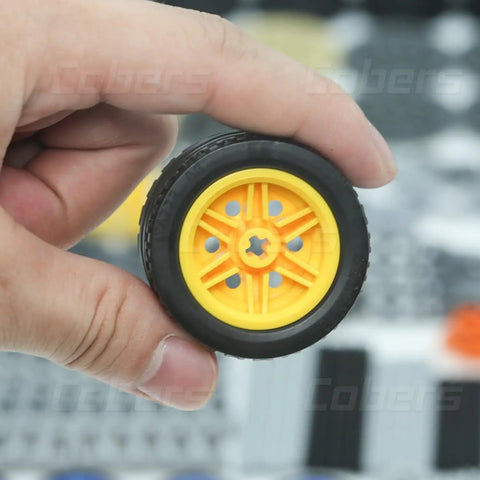 Hand holding yellow wheel from 852 Piece Technic Parts Kit With Gears And Axles For Builders Dope DIY Set Featuring Connectors