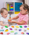 Two kids playing with 30 Pack Totally Rad Squishy Toys Mini Kawaii Mochi Squeeze Buddies on a table, soft colorful critters.