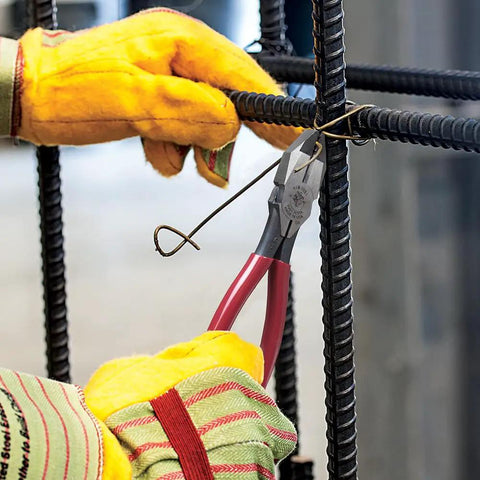 D201-7CSTA Linesman Pliers with spring-loaded action cutting rebar tie wire, shown with kickass grip and aggressive knurl.